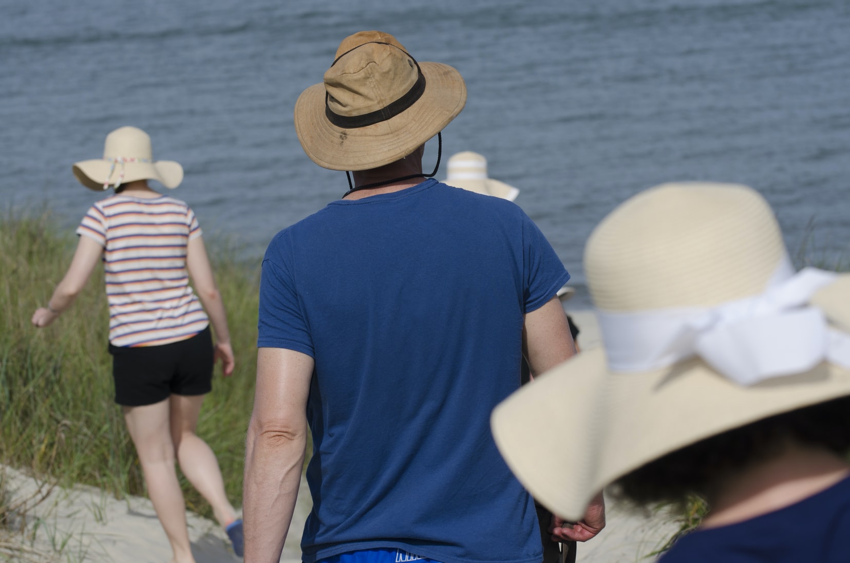 Family all wearing floppy  hats on the beach