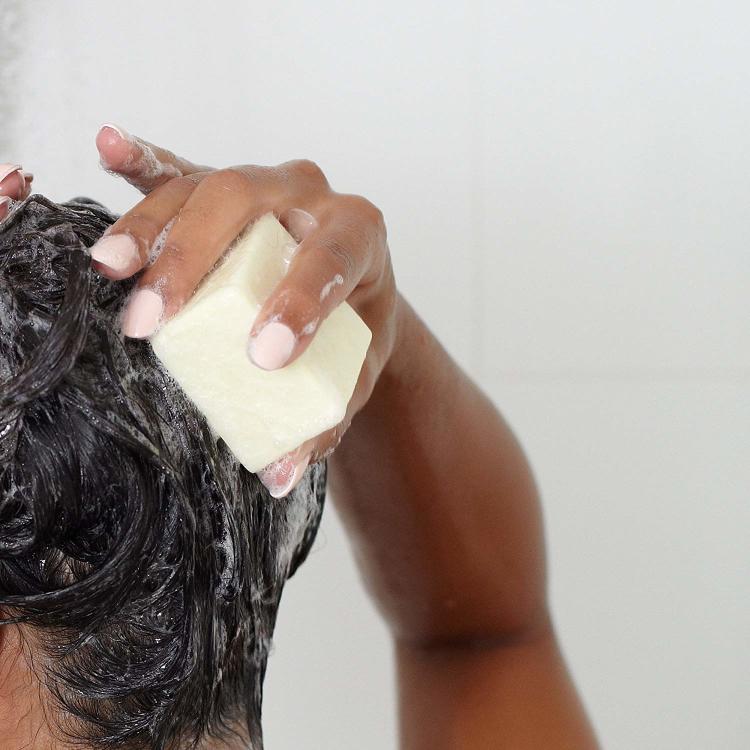 Woman washing her hair with the Ethique shampoo bar