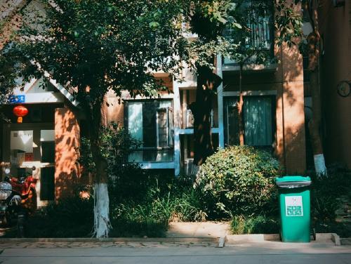 photo 3 front view of a house and a green trash bin outside