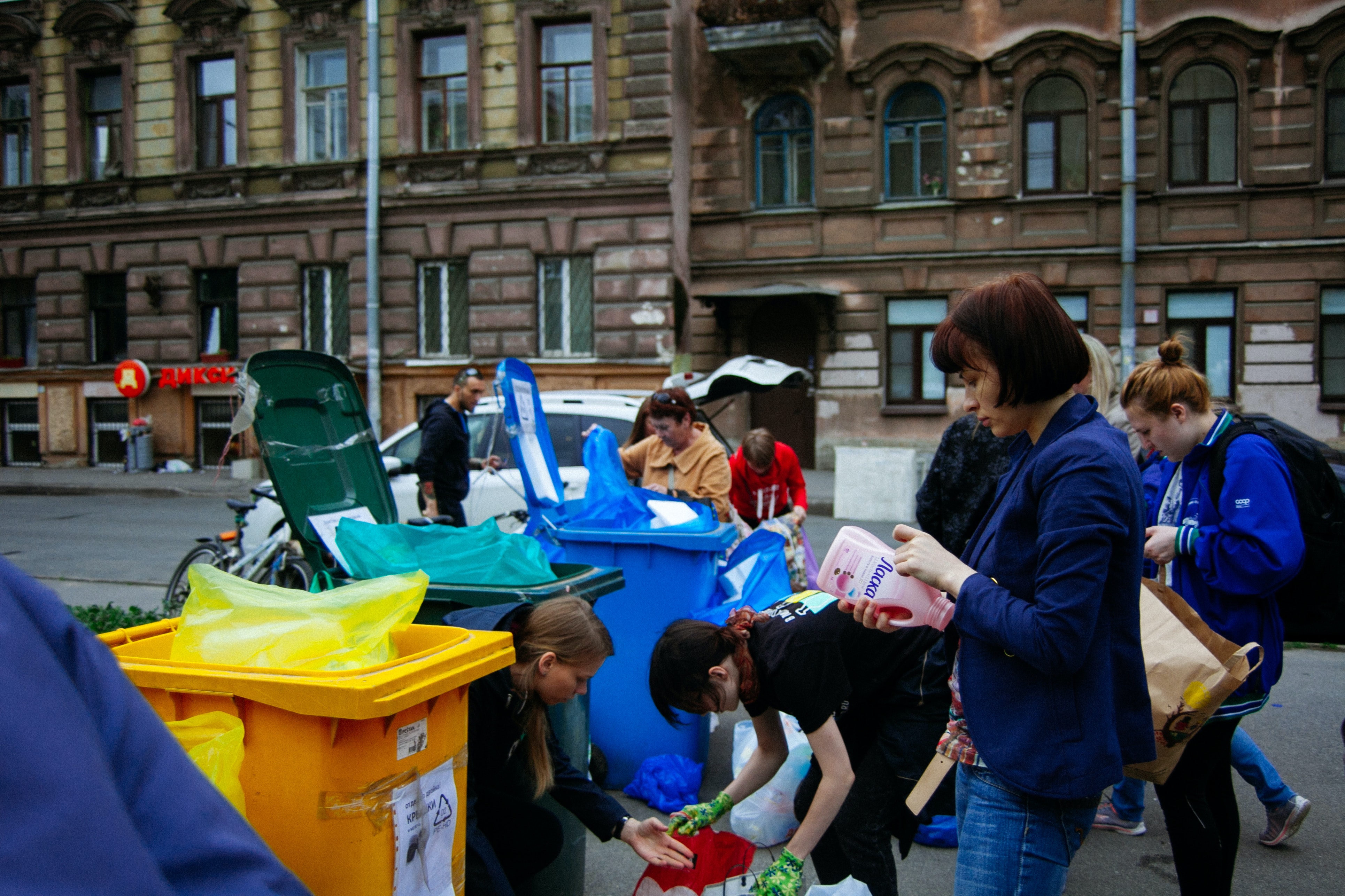 People approaching different containers for waste
