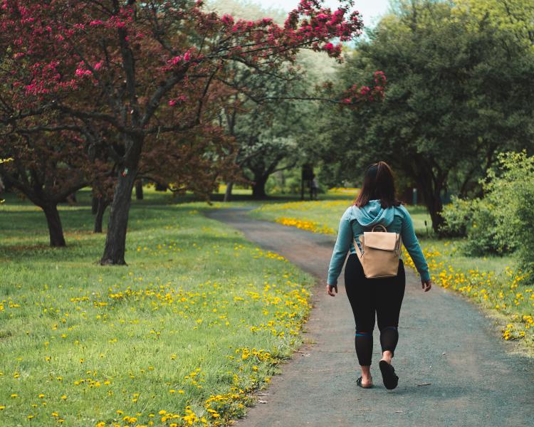 Woman walking There\'s a woman walking in a park.
