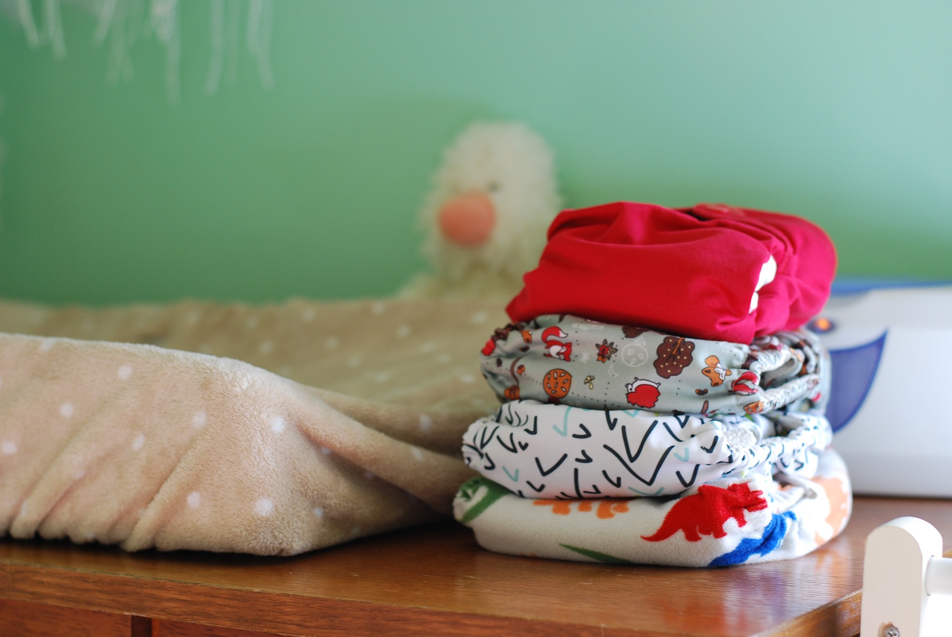 Four cloth diapers piled up on each other, with various colors and designs.