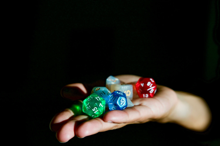 person holding hexagonal dices