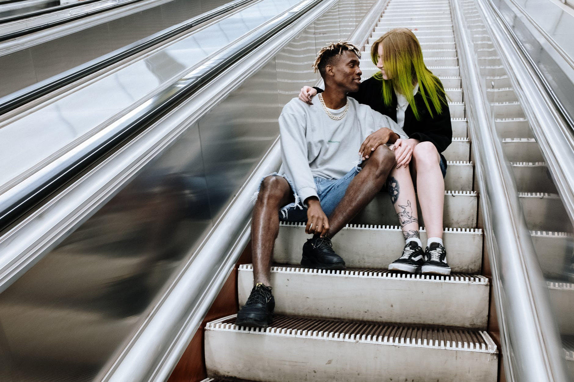 heterosexual couple sitting on stair looking at each other tenderly