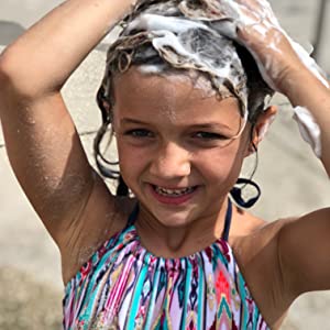 A little girl washing her hair with the Argan Vegan Shampoo Bar