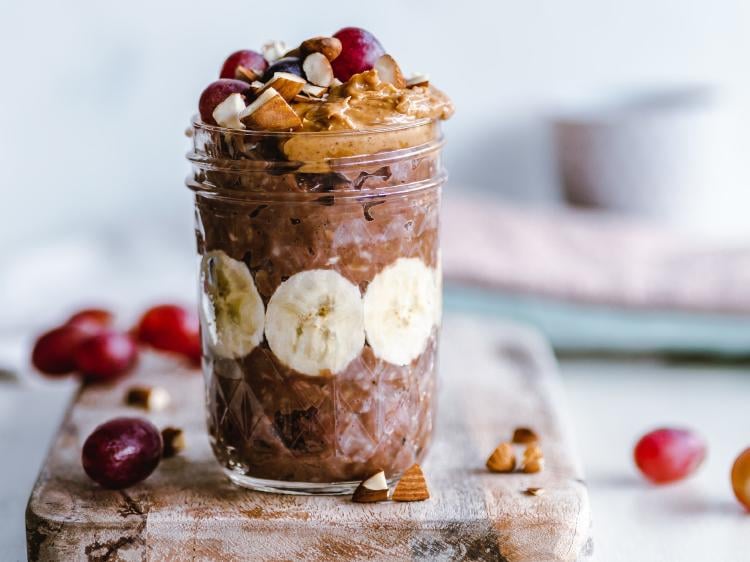 Glass with chocolate banana oats, topped with creamy peanut butter.