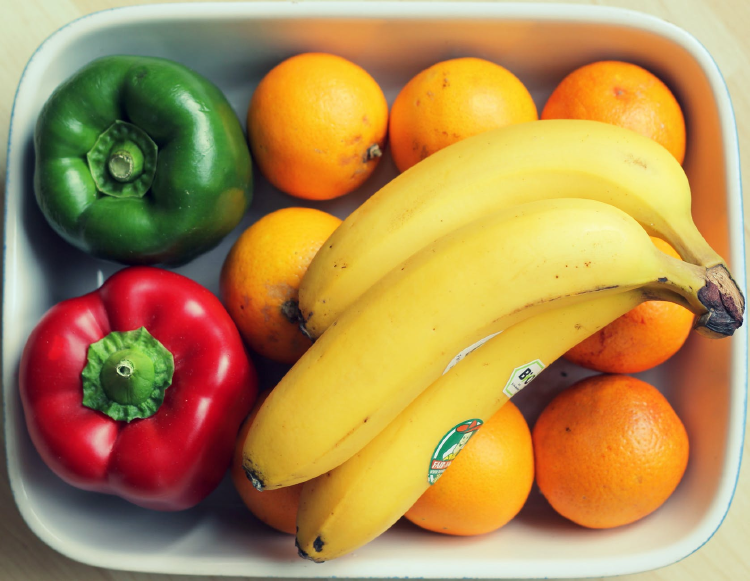 image top image of bananas, peppers and oranges on a rectangular dish