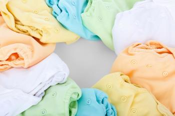 Reusable diapers of all colors laying on a surface, making a circle.