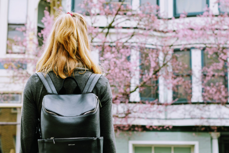 red haired girl wearing a black leather backpack