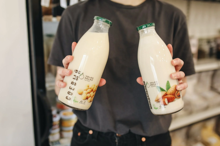 plant - based milk person holding a bottle of plant-based milk in each hand