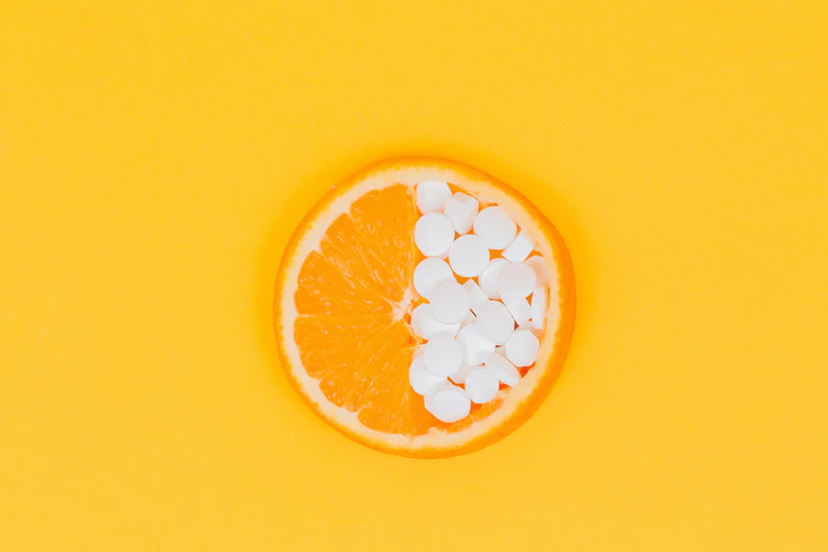 orange vitamins on a yellow, orange background