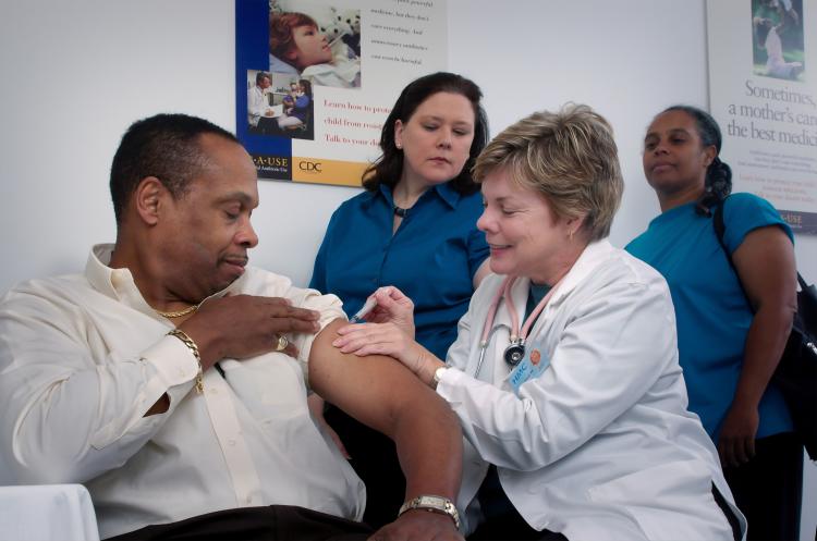 a doctor applying a shot to a patient