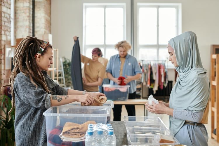 two women sourcing clothes to be recycled two women sourcing clothes to be recycled