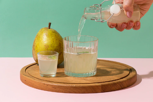 person pouring kefir water on a glass