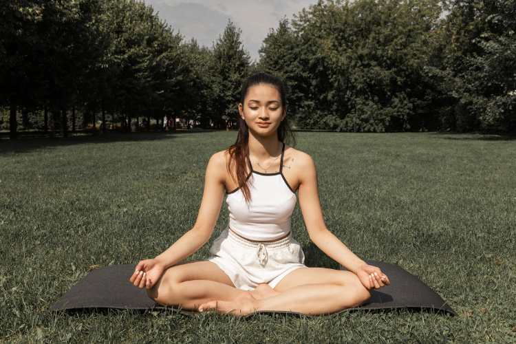 woman doing lotus position out in nature
