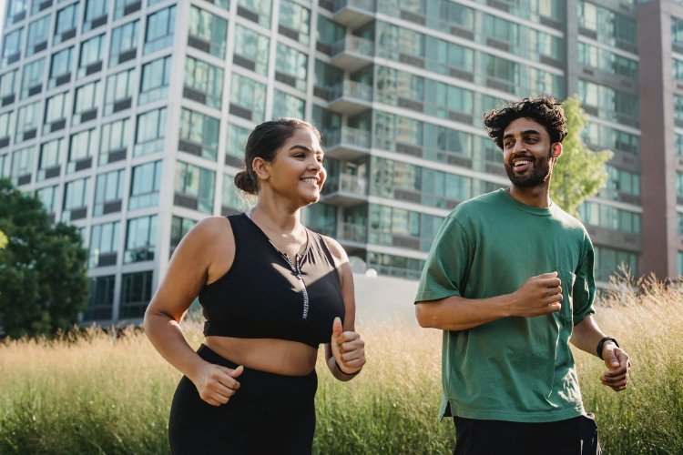 excersizing Man in Green Tank Top Standing Beside Woman in Black Tank Top doing Phisycal Activity